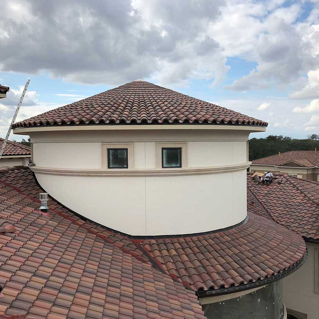 Spanish clay barrel-tile roof on an upscale Mediterranean-style home in the Greater Houston area, installed by Garrick Roofing