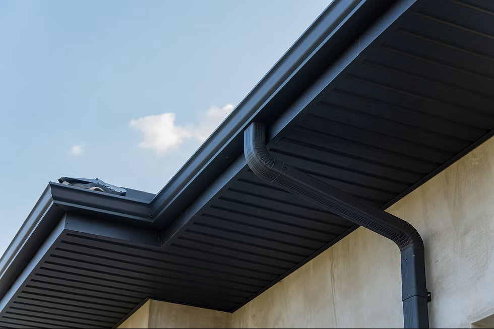 Black seamless gutters and downspout installed by Garrick Roofing on a Greater Houston home